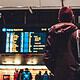 man standing at airport looking at travel directions
