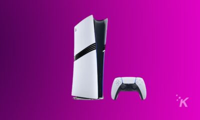 PlayStation 5 console and controller on pink background.