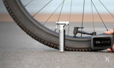 Person inflating bicycle tire with portable pump