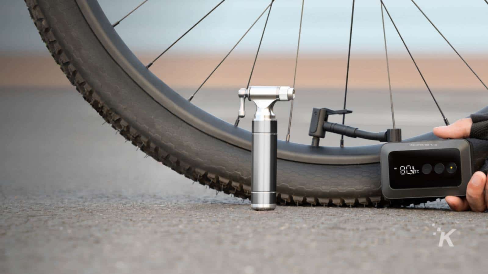 Person inflating bicycle tire with portable pump