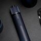 Electric screwdriver and folding knife on dark surface.