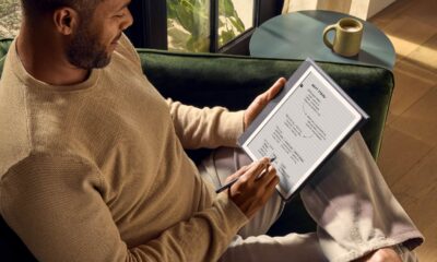 Person using digital notepad on green couch