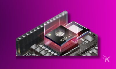 ESP32 microcontroller chip on pink background.