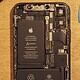 Disassembled smartphone showing internal battery and components.
