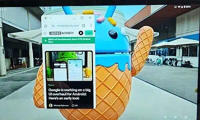 Android webpage open on laptop screen near statue.